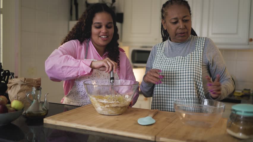 Happy African mother and daughter having fun preparing a homemade dessert Royalty-Free Stock Footage #1101953485