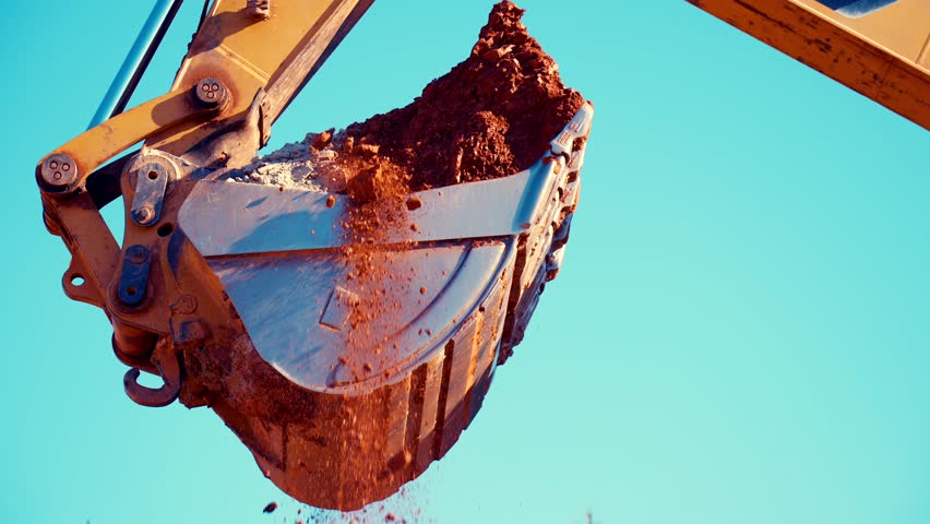 An excavator is loading clay into a dump truck, early in the morning, in a clay quarry. 25prc slow motion. 4k. Royalty-Free Stock Footage #1101953949