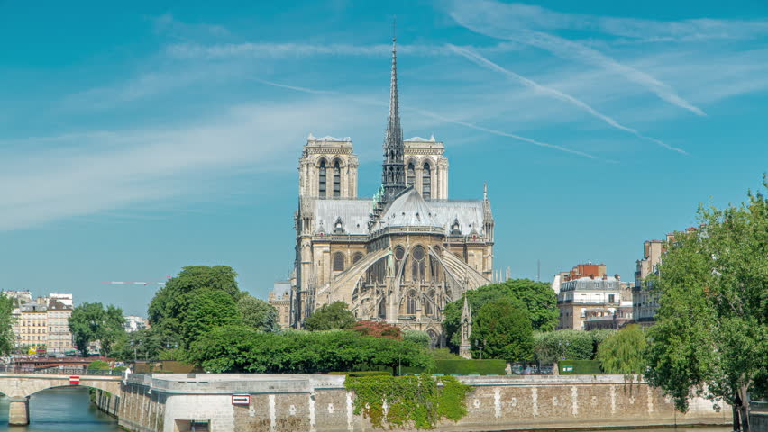 Notre Dame de Paris back side timelapse. One of the most famous symbols of Paris. View from Tournelle bridge with boats on Siene river at sunny summer day