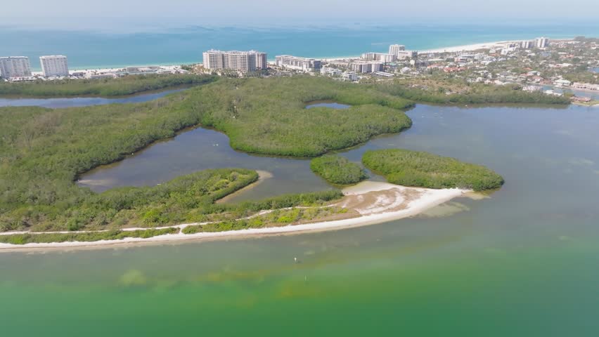 Aerial view of Florida mangrove tunnels with Lido Key city skyline in the background.
