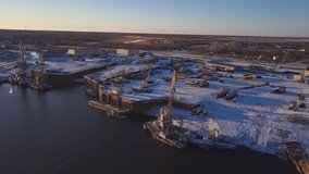 Top view of embankment with ships on winter day. Clip. Beautiful winter sport of cargo ships. Port of cargo ships with small village on winter day