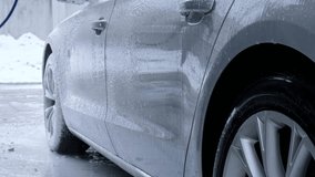 Washing luxury silver car on touchless car wash. Washing sedan car with foam self-service and high pressure water. Winter cleaning in car wash. Cleanliness and order in urban environment Man hands - Powered by Shutterstock - Get 15% off with code: PIKWIZARD15