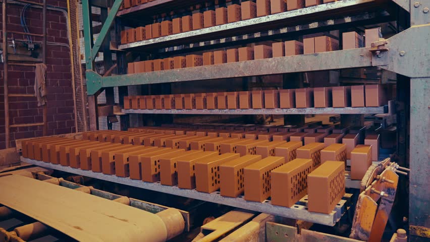 Brick production line. Fresh clay bricks being put on shelves for drying. 4k. Royalty-Free Stock Footage #1101960701