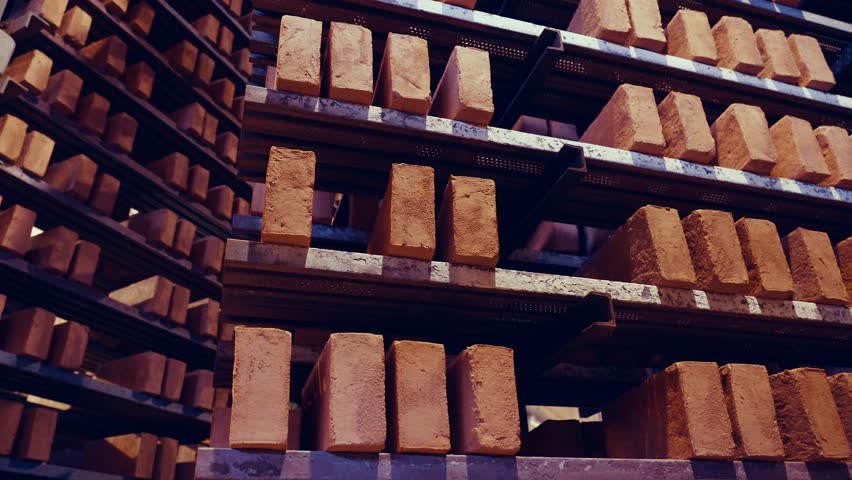 Rotating shelves of red oldschool bricks. Dried bricks from the kiln, before laying and firing. Brick production factory. 4k.