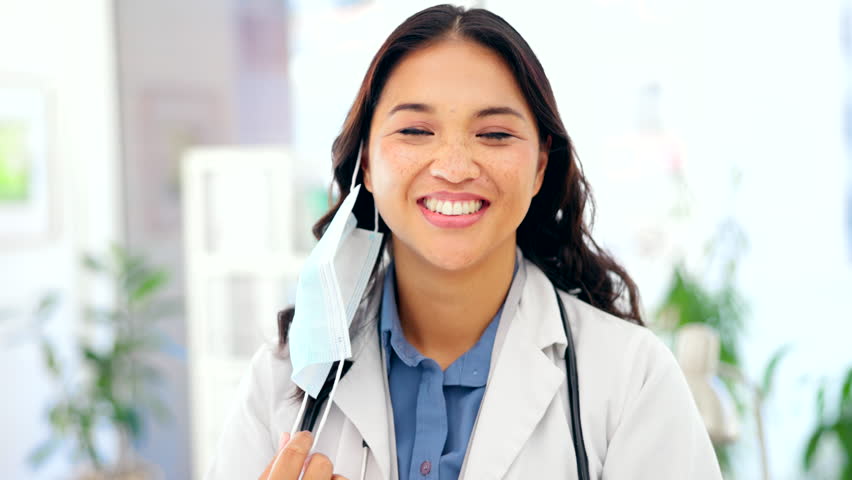 Doctor, woman and mask off face with smile for success, happiness and stop of covid in hospital. Asian medic, happy and remove ppe in office at clinic for healthcare, wellness and medical service | Shutterstock HD Video #1101962749