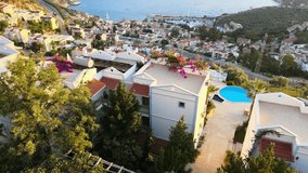 Aerial video highlighting the captivating landscape of Kalkan, a coastal town located close to Kaş, featuring the marina, turquoise waters, and the enchanting atmosphere of the Mediterranean in Antaly