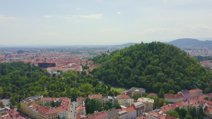 Inscription on video. Graz, Austria. The historic city center aerial view. Mount Schlossberg (Castle Hill). Name is burning, Aerial View