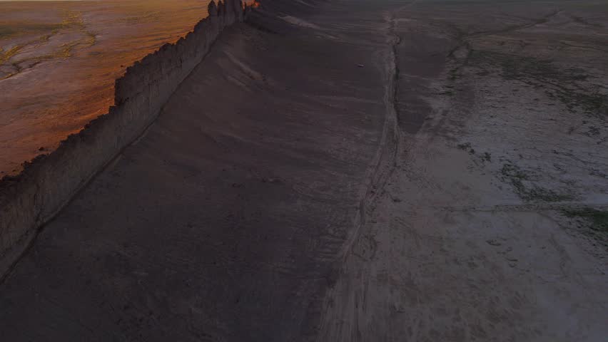 Aerial rising shot of Shiprock in New Mexico desert at sunset