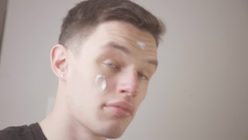 Man Spreading Moisturizing Cream On His Face By His Hands. - close up | Shutterstock HD Video #1101972477