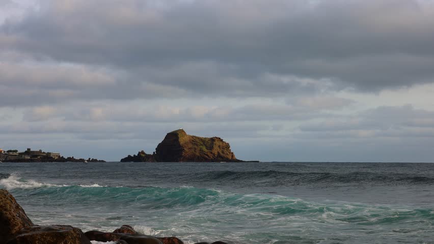 4K video of a rock in the Atlantic Ocean with a lighthouse on it on a stormy day.