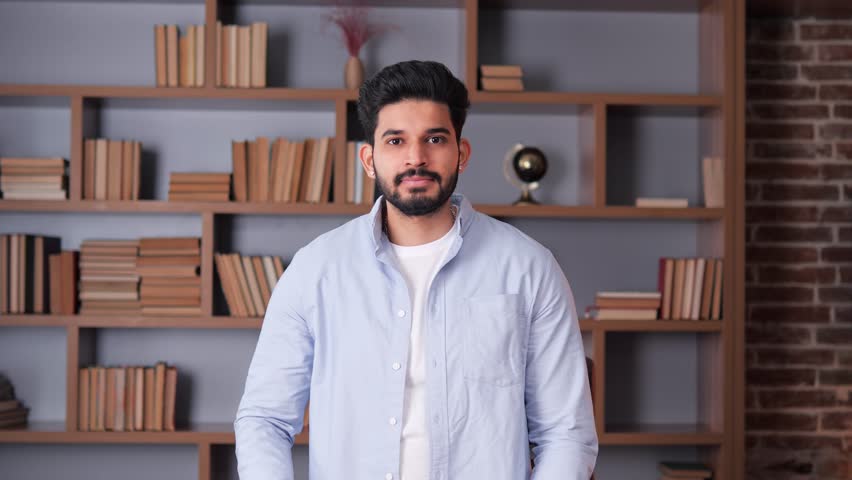 Handsome, wise, cheerful Indian man with a beard wearing a blue shirt is gesturing okay sign in an office. Everything is Fine, Okay Sign, Gesture. Looking at camera showing okay gesture good mood.