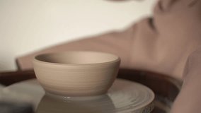 potter's wheel and earthenware. master woman separates pottery from the potter's wheel. real time video.close up. High-quality Full HD video recording