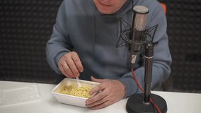 a man in headphones eats instant noodles from a box. High quality Full HD video recording 