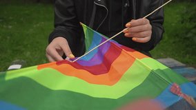 assembling a kite. a woman with orange manicure holds a kite in her hands. close-up. real time video. High-quality Full HD video recording