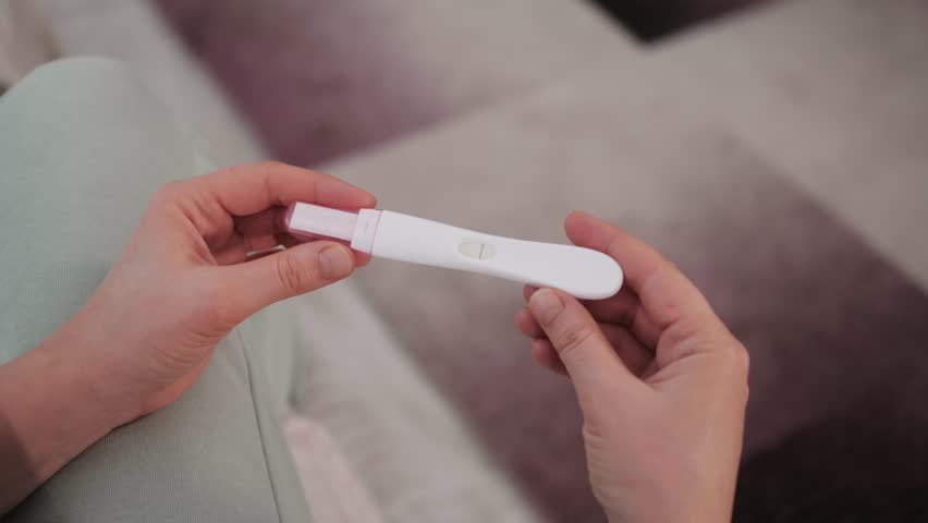 Woman with anxious feelings. Girl with a negative pregnancy test. Close-up of hands holding pregnancy test. Royalty-Free Stock Footage #1101981599