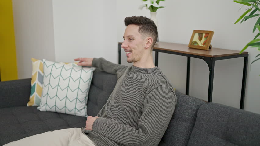 Two men couple hugging each other holding gift at home
