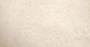 4K footage vertical video Top view SLO MO CU, milk surface with lots of bubbles floating on milk surface.