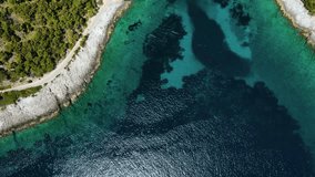 Aerial top down view of turquoise water bay with beach and yacht on island Hvar, Dalmatia, Croatia. Summer vacation destination. 4k drone video