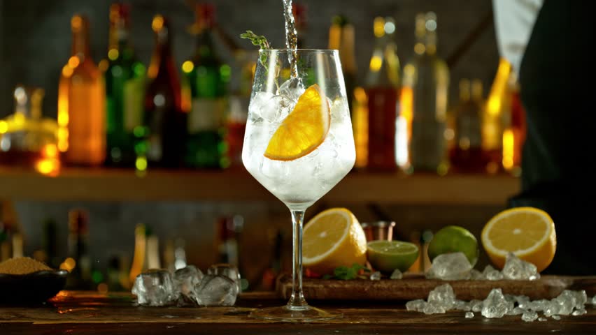 Super slow motion of preparing gin and tonic drink with speed motion. Filmed on high speed cinema camera, 1000 fps, placed on high speed cine bot. Bar with bottles on background. Speed ramp effect. Royalty-Free Stock Footage #1101993751