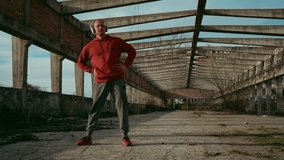 4k video footage of A man warms up before training on the ruined building, spring. Fitness Training Outdoor. Healthy Lifestyle. Urban city lifestyle outdoors concept