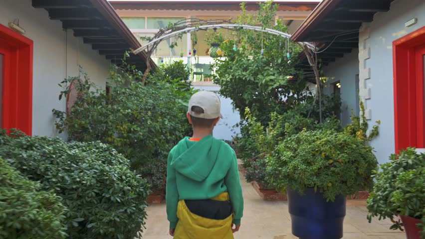 Boy walking like a plane in a garden. 4k footage UHD 3840x2160 