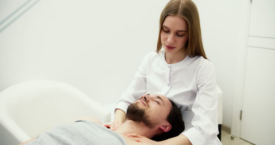 Female master doing therapeutic massage of the head and neck for man | Shutterstock HD Video #1102003591