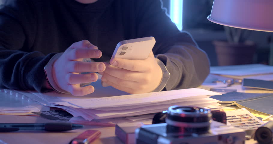 He holds phone on table documents. There metal handcuffs wrists. Writing message representative hands teenager use LTE mobile phone table. Phone call lawyer. | Shutterstock HD Video #1102005577