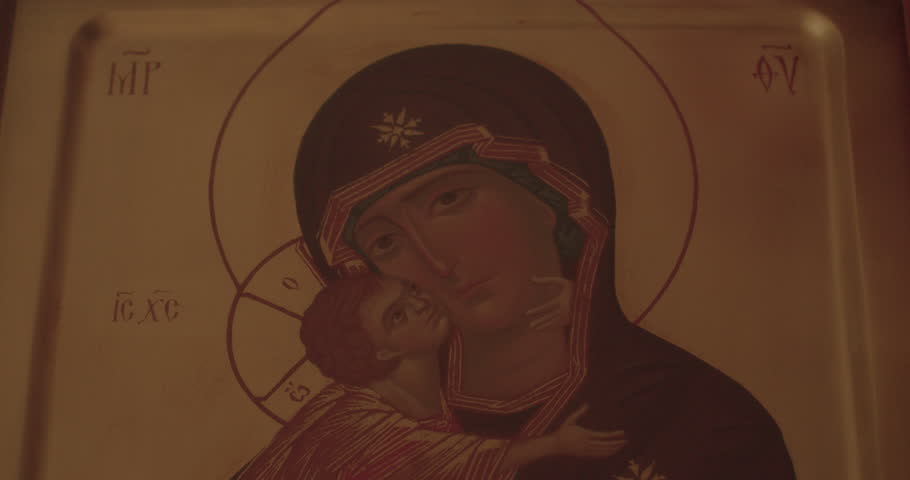 Hand wipes white cloth drawing icons in the church. Kisses the object in the bokeh. A dark room for prayer for financial growth.