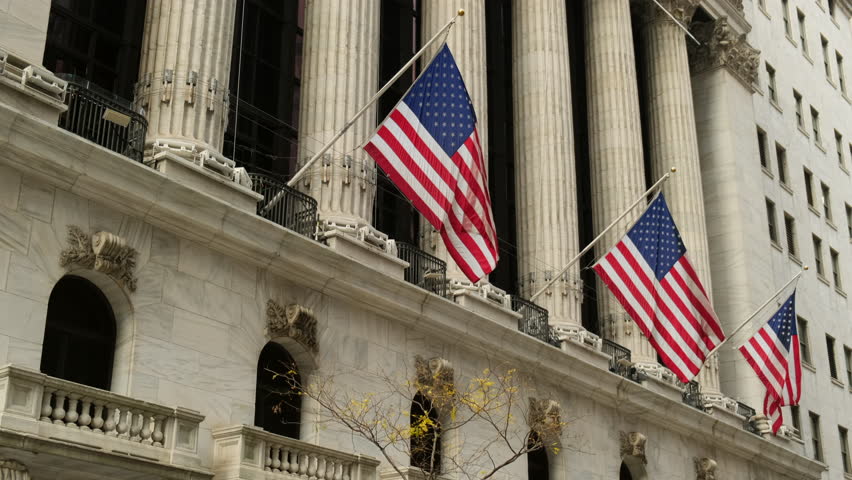 Famous Wall street and the building in New York, New York Stock Exchange with patriot flag. Wall Street road sign in the corner of New York Stock Exchange. New York Stock Exchange Royalty-Free Stock Footage #1102007453