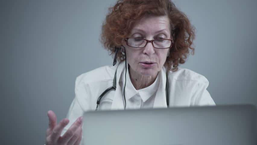 Telemedicine services. Primary care consultations, psychotherapy, emergency services. Female doctor talking and gesturing while having online consultation on laptop. Medicine, healthcare concept. | Shutterstock HD Video #1102007591