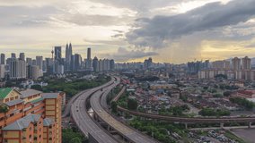 High angle aerial time lapse video of sunset overlooking an urban village with busy expressway against Kuala Lumpur skyline in Malaysia. No Logo. High quality, Prores Full HD Timelapse