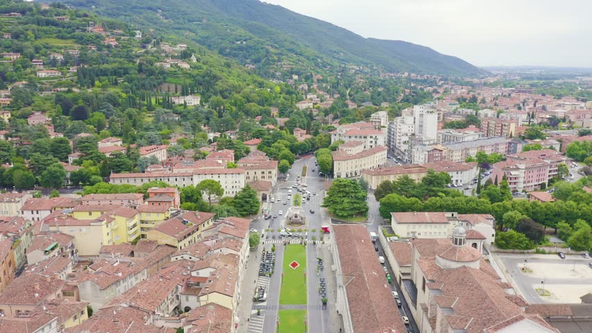 Inscription on video. Brescia, Italy. Monument to Arnaldo da Brescia. Arnaldo Square. Glitch effect text, Aerial View, Departure of the camera