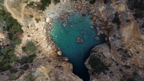 Aerial view of turquoise clear water in a small bay. A little-known tourist attraction of Turkey is Delik Deniz in Gazipasa. Beautiful Mediterranean natural pattern. Abstract natural video background