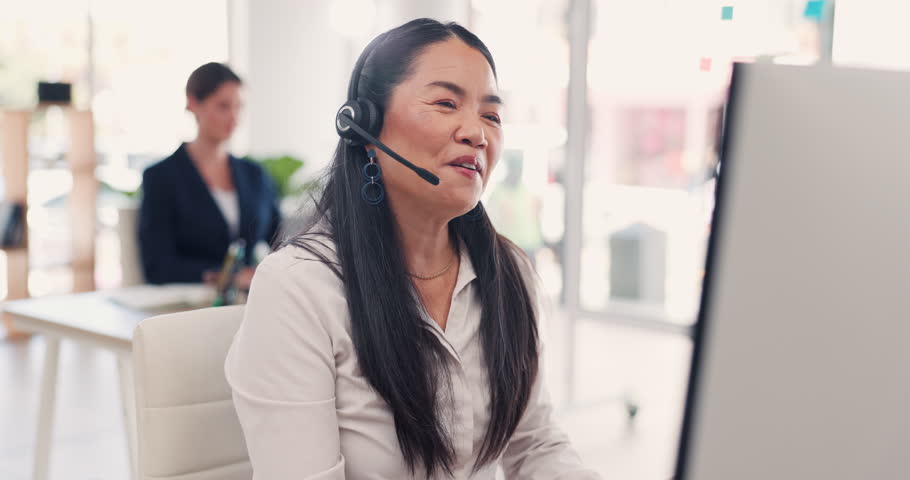 Asian woman, call center and consulting on computer in customer service, telemarketing or support at office. Female consultant agent talking with headphones to client for online advice or help on PC | Shutterstock HD Video #1102018707