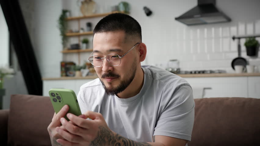 Man Showing Smartphone Green Screen At Camera. Smiling Asian man holding chroma key screen at camera. Royalty-Free Stock Footage #1102023683