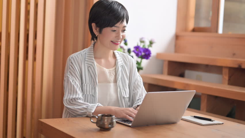 Video of a middle-aged Asian woman on a laptop