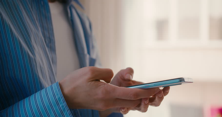 Woman touching scroll page app on mobile phone, close-up shot