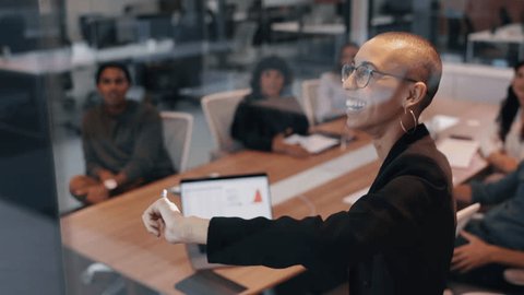 Confident female professional giving a presentation in a meeting, addressing her team on a project and sharing her ideas. Young business woman taking the lead on an office collaboration. Stock video