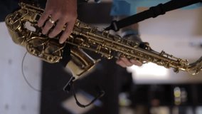 caucasian male musician in a blue shirt with a wedding ring on his hand plays the saxophone, vertical video. Close up footage of Musician saxophonist plays music on his instrument. vertical video - Powered by Shutterstock - Get 15% off with code: PIKWIZARD15