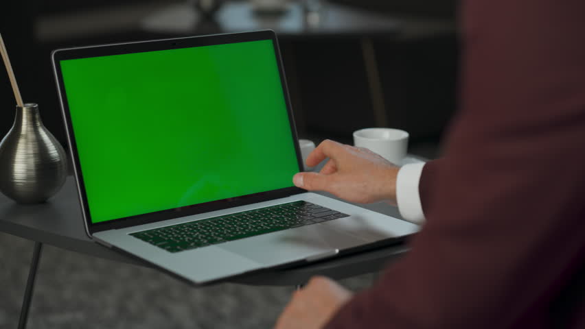 Anonymous director touching chromakey laptop at lobby closeup. Entrepreneur arms using touchpad on green screen device keyboard. Unknown ceo working macro view. Executive hands searching information 