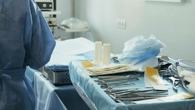 Preparation for the surgery. Surgery tools. Multiple surgery tools on the table in operating room. Scrub nurse hands in rubber gloves. Modern medical concept. - Powered by Shutterstock - Get 15% off with code: PIKWIZARD15