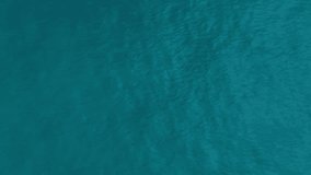 Ocean surface aerial view, sea water texture background by drone. Flying over the blue ocean in the azure lagoon. Travel concept. Aerial footage. Slow motion 120 fps video