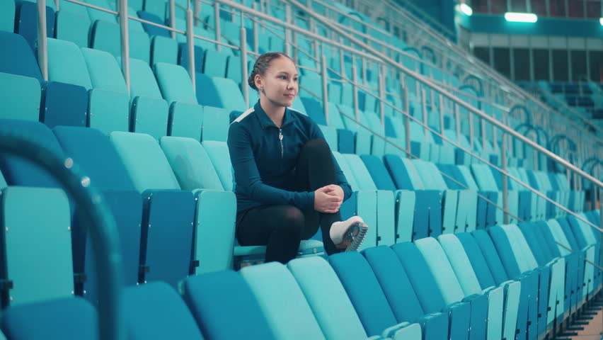 Sports arena with a young female skater on the seats