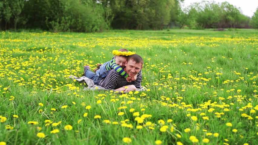 father playing with his son in a spring meadow
