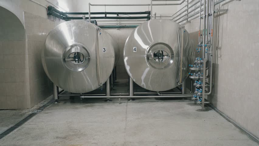 A brewery shop with huge steel tanks that store beer in a brewery.