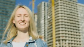 Close-up of female tenant or owner shows keys and keychain in form of house against background of newly built building - symbol of family hearth and own housing. Purchase of real estate. - Powered by Shutterstock - Get 15% off with code: PIKWIZARD15