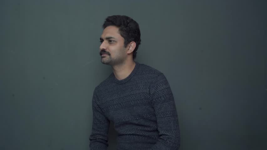 a pakistani asian man giving reaction in fron of camera screen