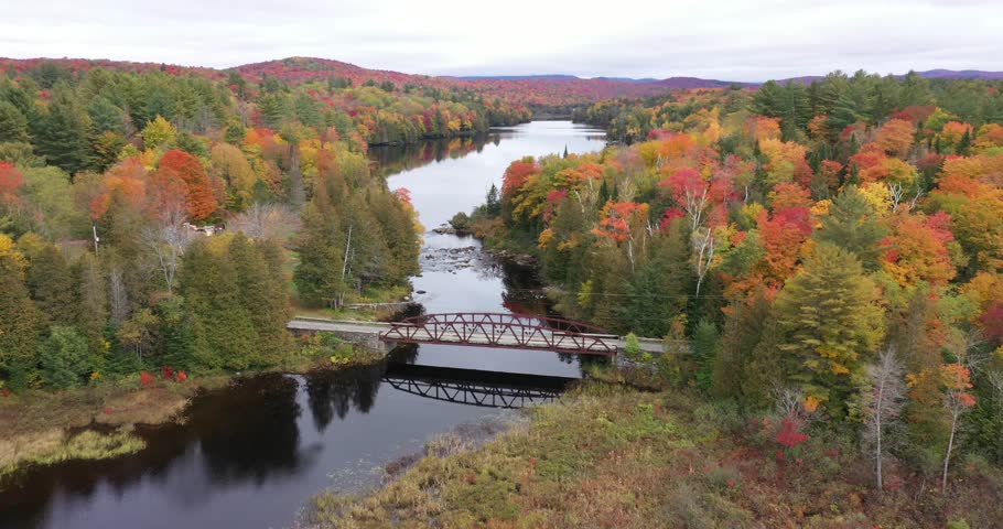 Aerial view of the bridge and surrounding river and countryside of the Santanoni Preserve near Newcomb, New York in Adirondack Park during autumn.
