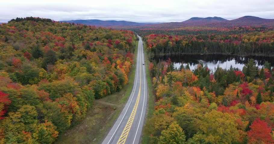 State Highway 3 slices through the colorful autumn landscape past Panther Pond near Panther Mountain Bog in Adirondack Park in Upstate New York.