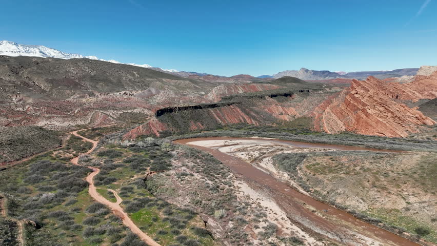 Aerial southern Utah Virgin River red rock mountains trails. Southwestern desert Utah near St George. Red stone and black volcanic mountain landscape. Geological landscape wind, weather, water erosion